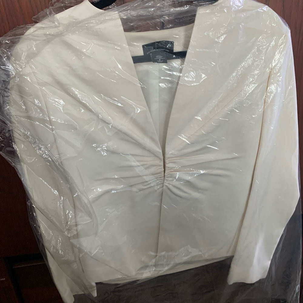 Cream color blazer, sit just above the hips. Ruched mid center.